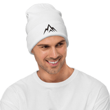 Man wearing a white Unshaken Apparel Embroidered Beanie with mountain logo, showcasing strength and faith.